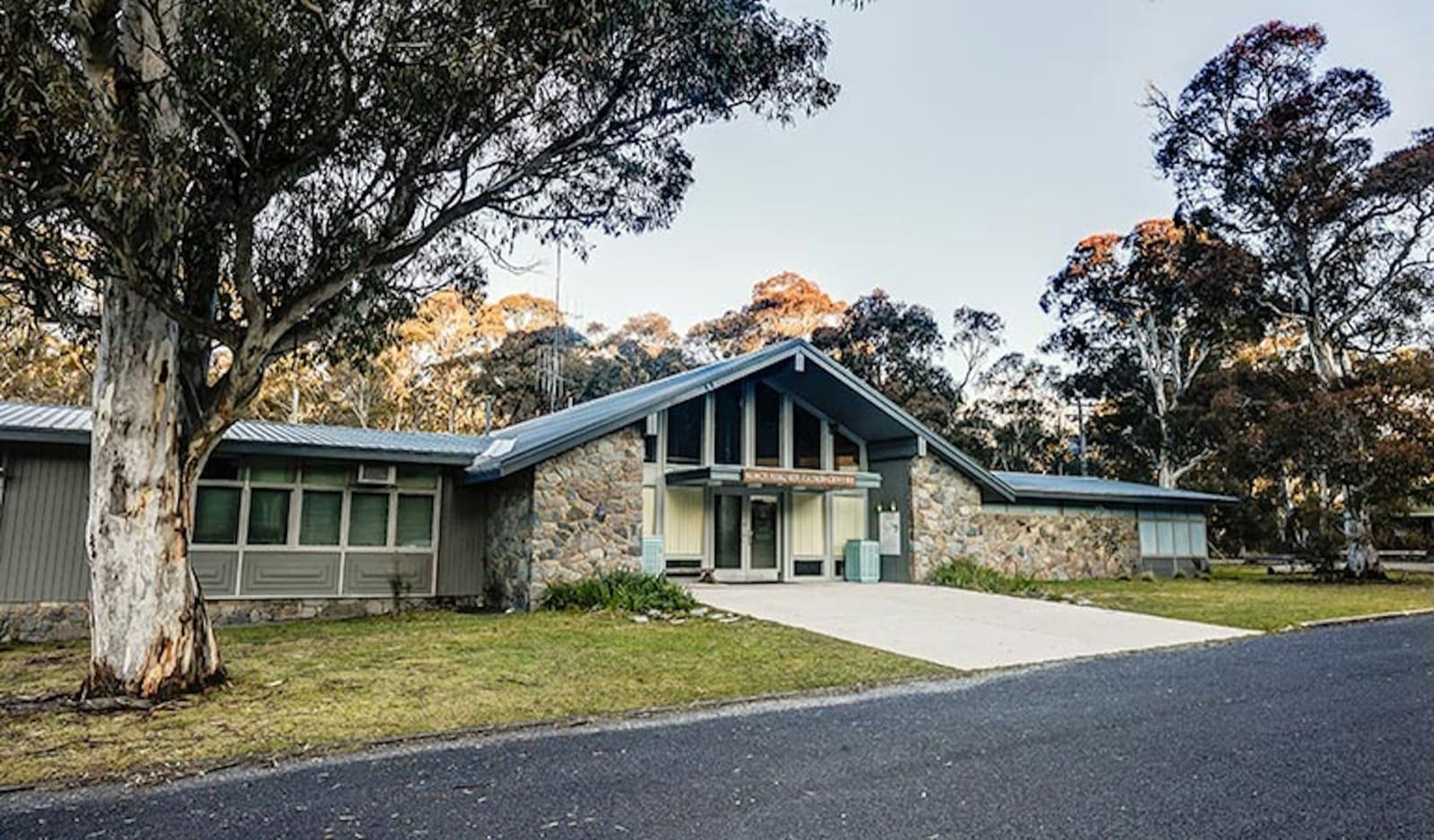 Stone and timber education centre building among snowgums