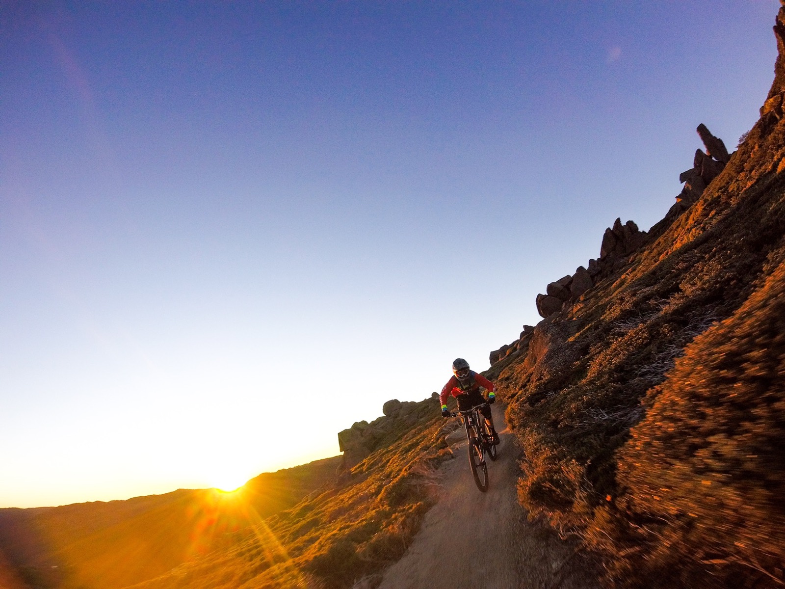A mountain biker descending at sunrise in the Snowy Mountains